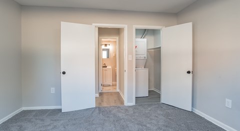 A room with a carpeted floor and a doorway leading to another room.