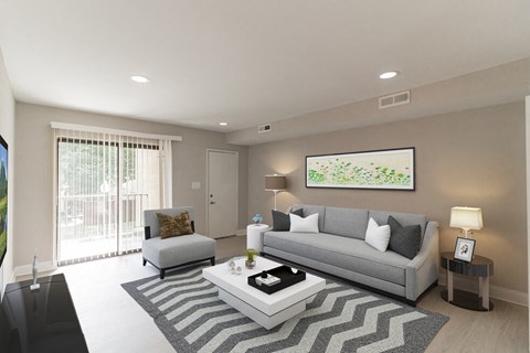 A living room with a grey couch, a coffee table, and a painting on the wall.