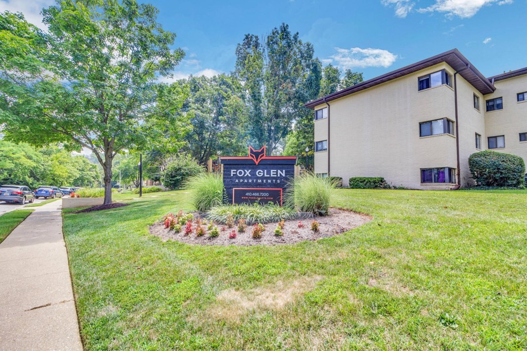 A sign for Fox Glen Apartments is in front of a building.