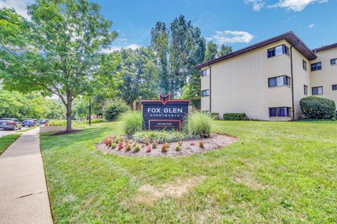 A sign for Fox Glen Apartments is in front of a building.