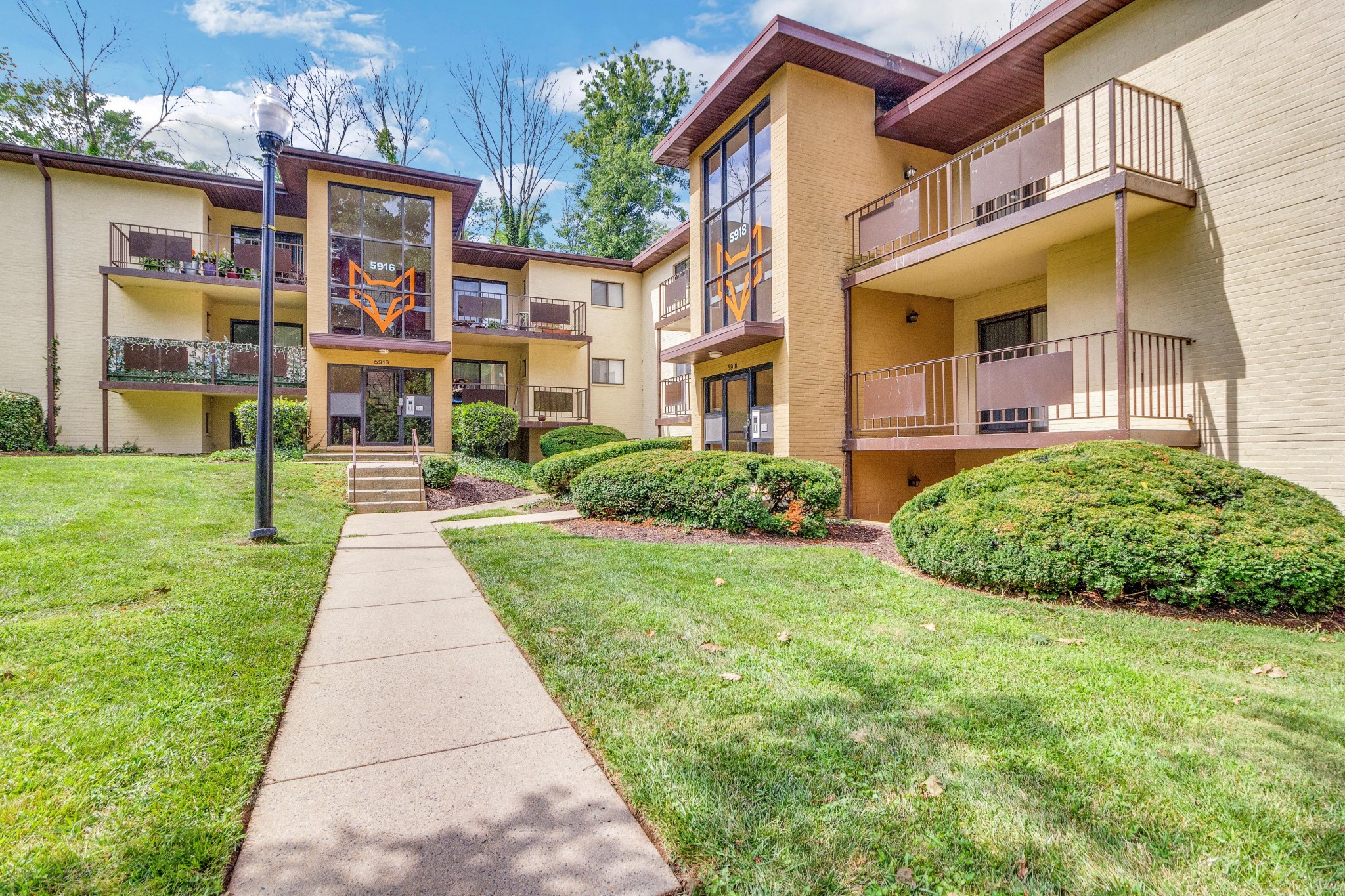 an exterior view of an apartment building with a sidewalk and grass