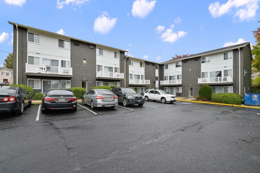 a parking lot with cars in front of an apartment building