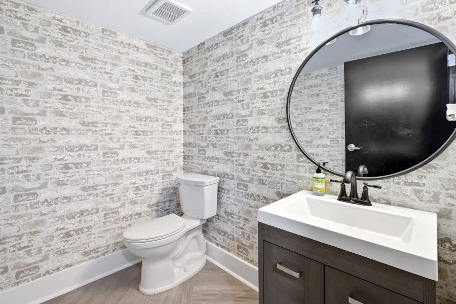 a bathroom with a toilet and a sink and a mirror