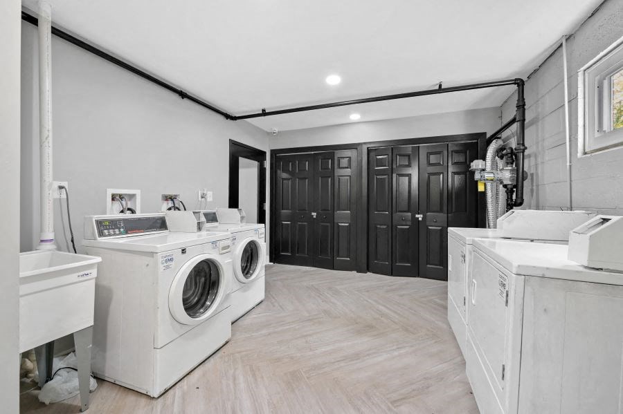 a white laundry room with washing machines and other appliances