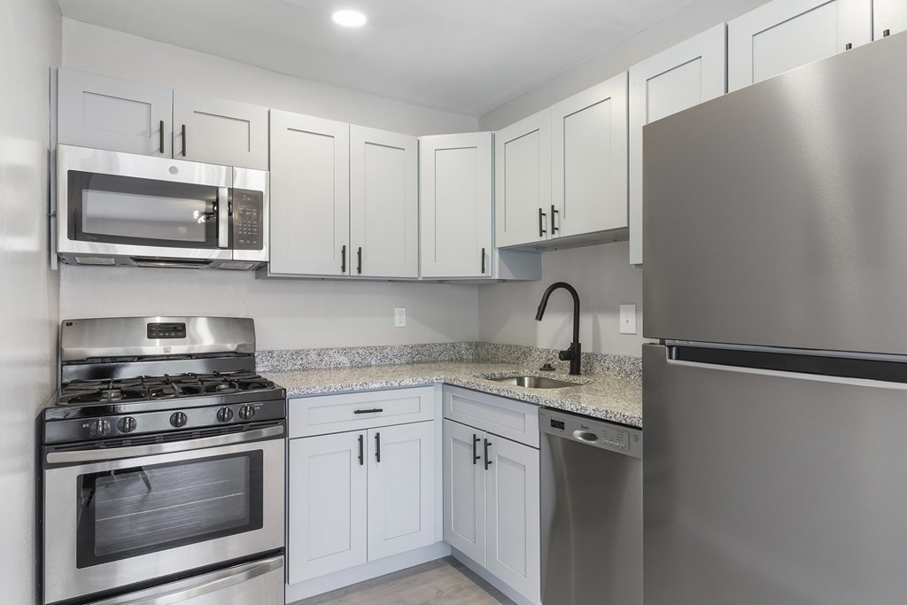 A modern kitchen with stainless steel appliances and white cabinets.