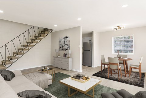 a living room with a couch and a table and a staircase