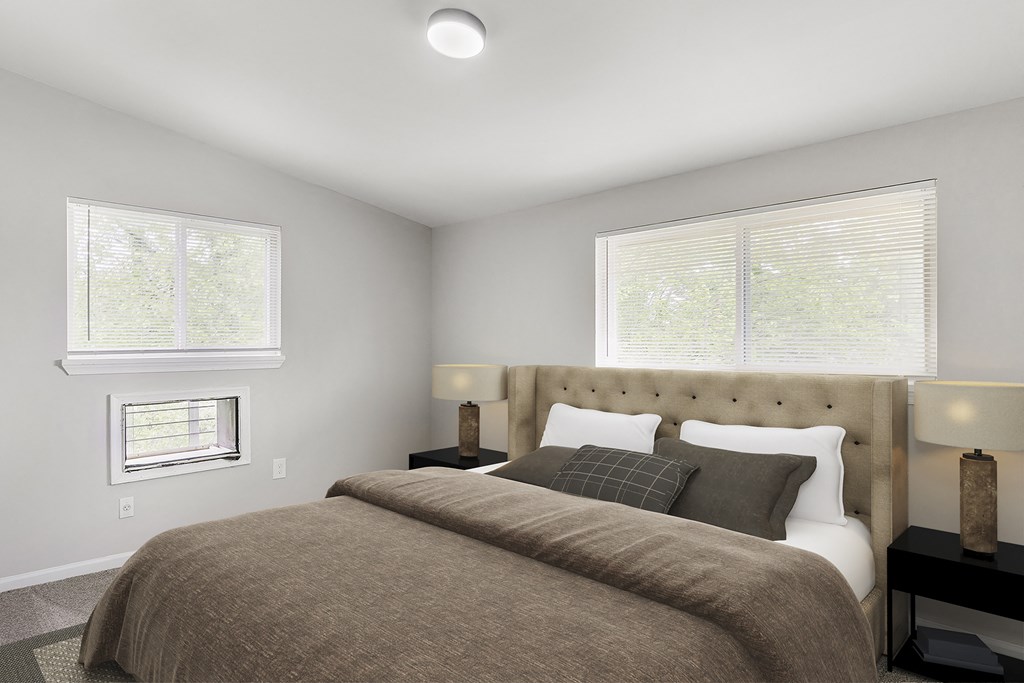 a bedroom with a bed and two windows