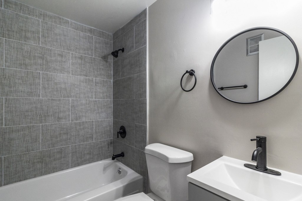 A bathroom with a white toilet, sink, and tub.