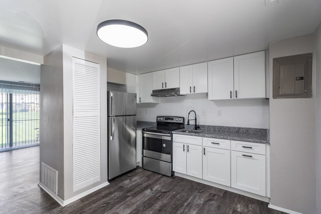 A modern kitchen with white cabinets and stainless steel appliances.