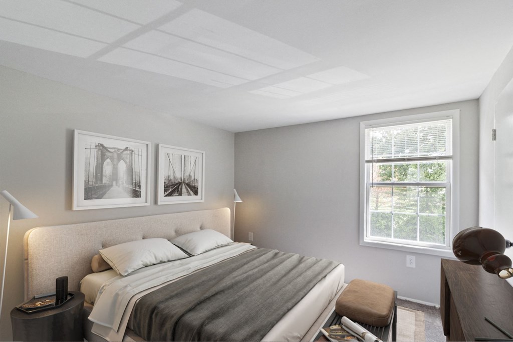 A bedroom with a bed, nightstand, and two pictures on the wall.