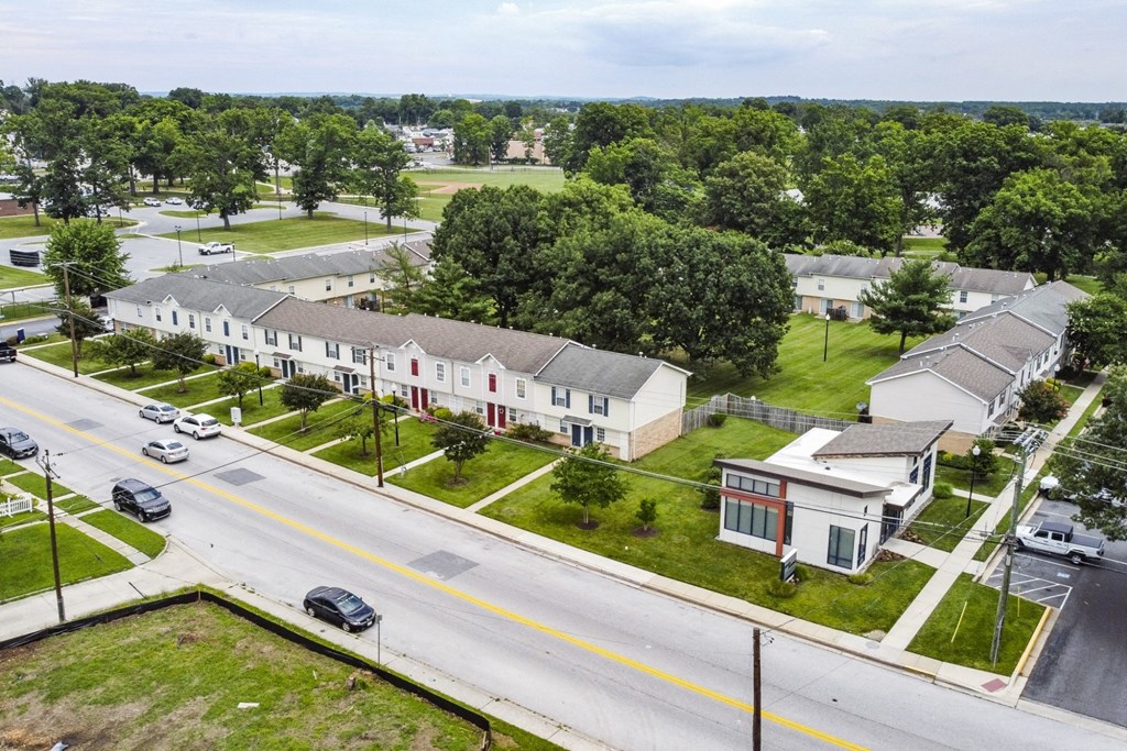 A street view of a residential area with houses and cars.