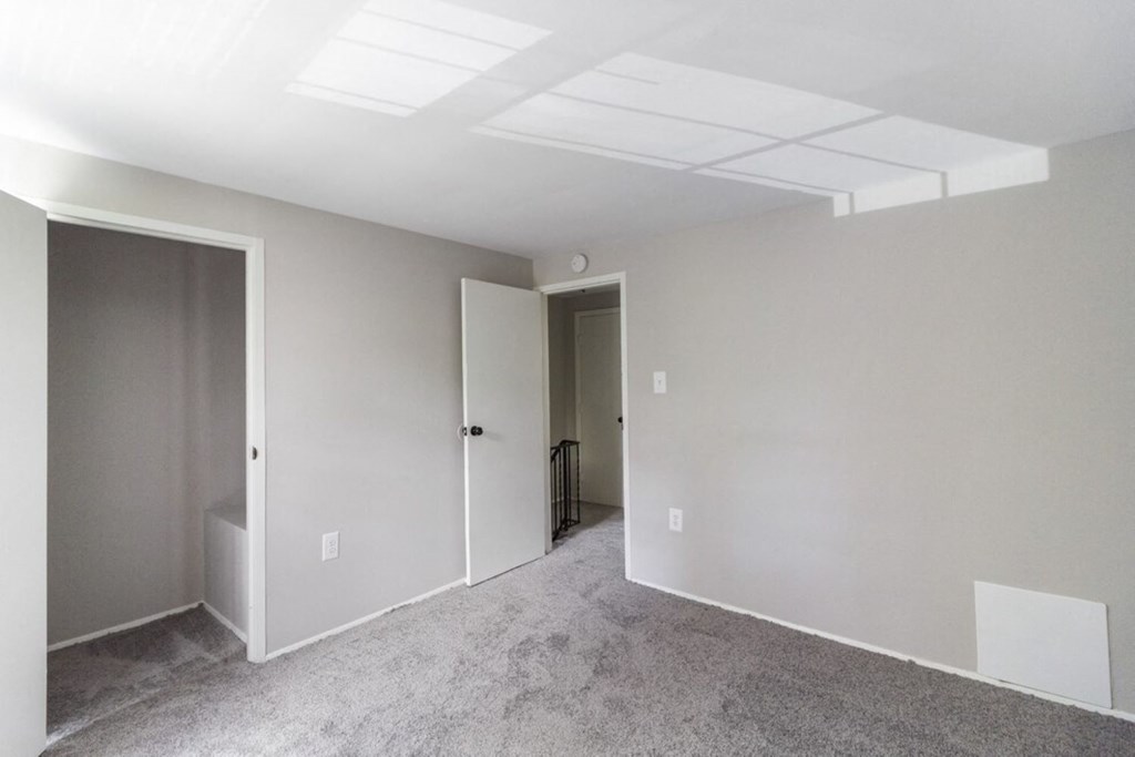 A room with a carpeted floor and a white ceiling with lights.