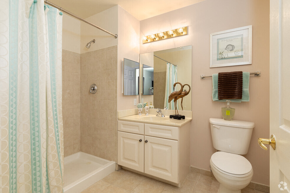 a bathroom with a shower and a toilet and a sink