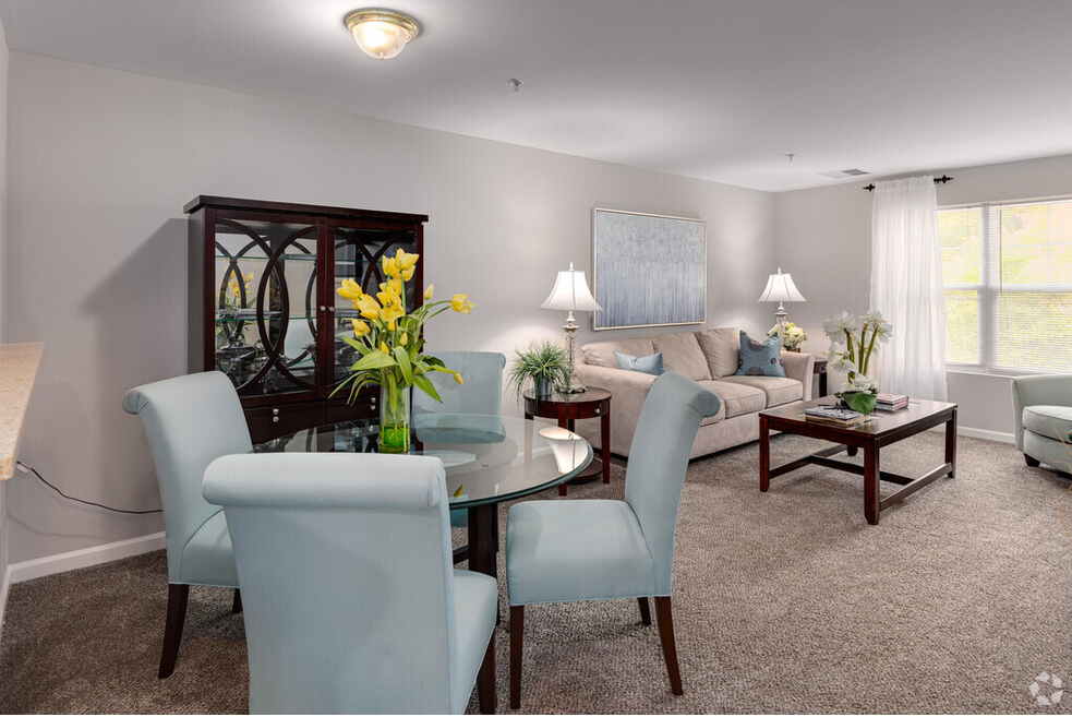 a living room and dining room with a table and chairs