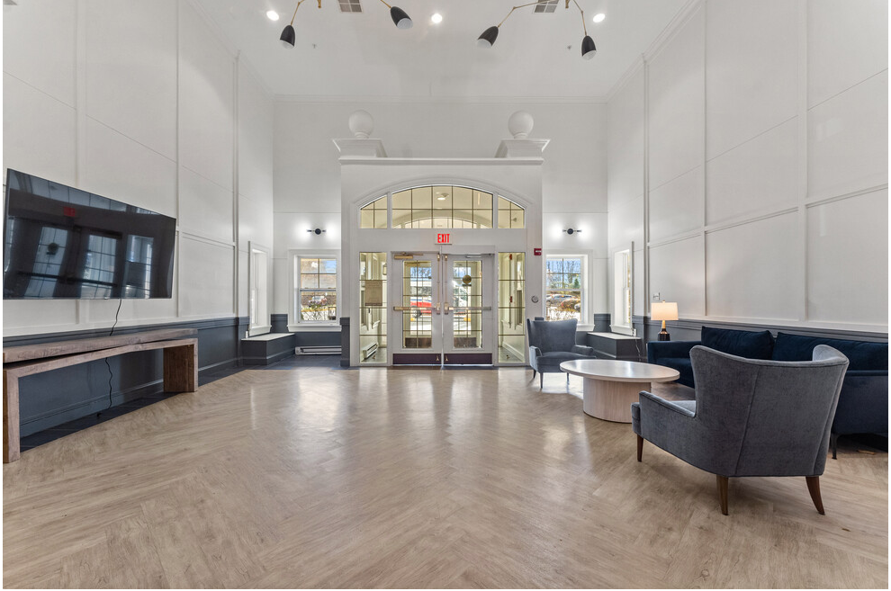 a large lobby with chairs and tables and a tv