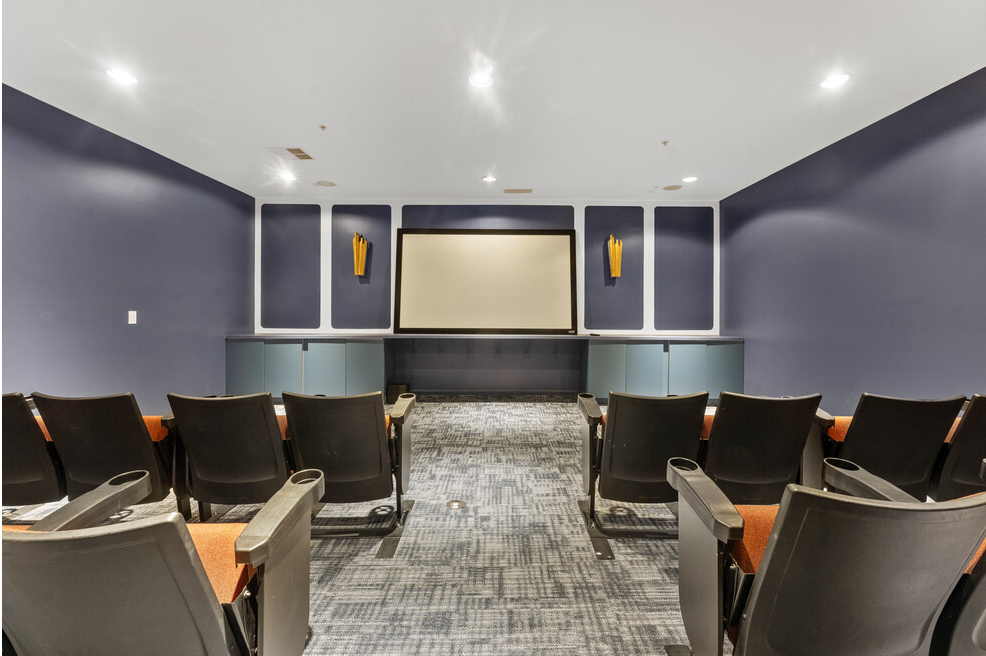 room with chairs and a projector screen in the center of a room