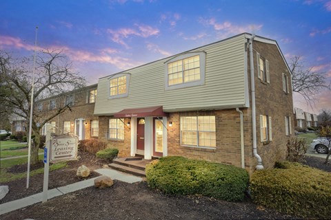 A house with a sign that says "Leasing Center" in front of it.