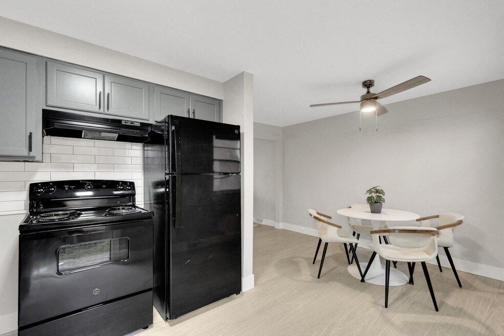 A kitchen with black appliances and a white table.