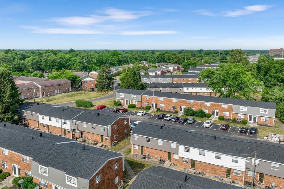A view of a residential area with multiple brick houses and cars parked in the driveways.