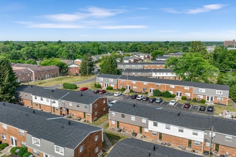 A view of a residential area with multiple brick houses and cars parked in the driveways.