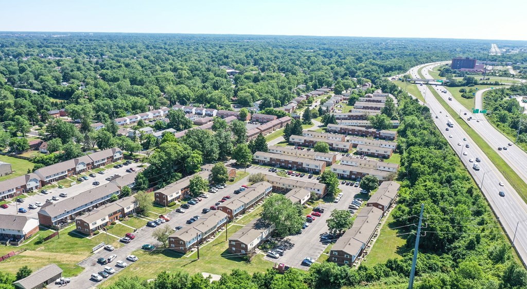 A bird's eye view of a residential area with a highway running alongside.