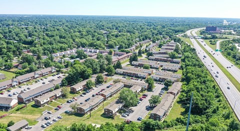 A bird's eye view of a residential area with a highway running alongside.