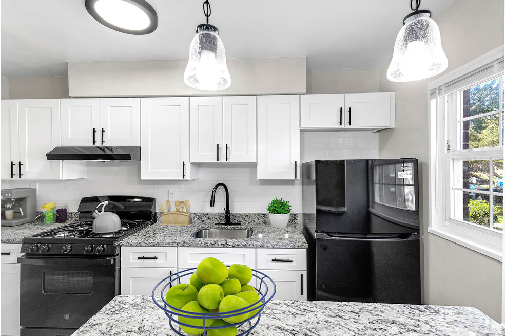 a kitchen with black appliances and white cabinets