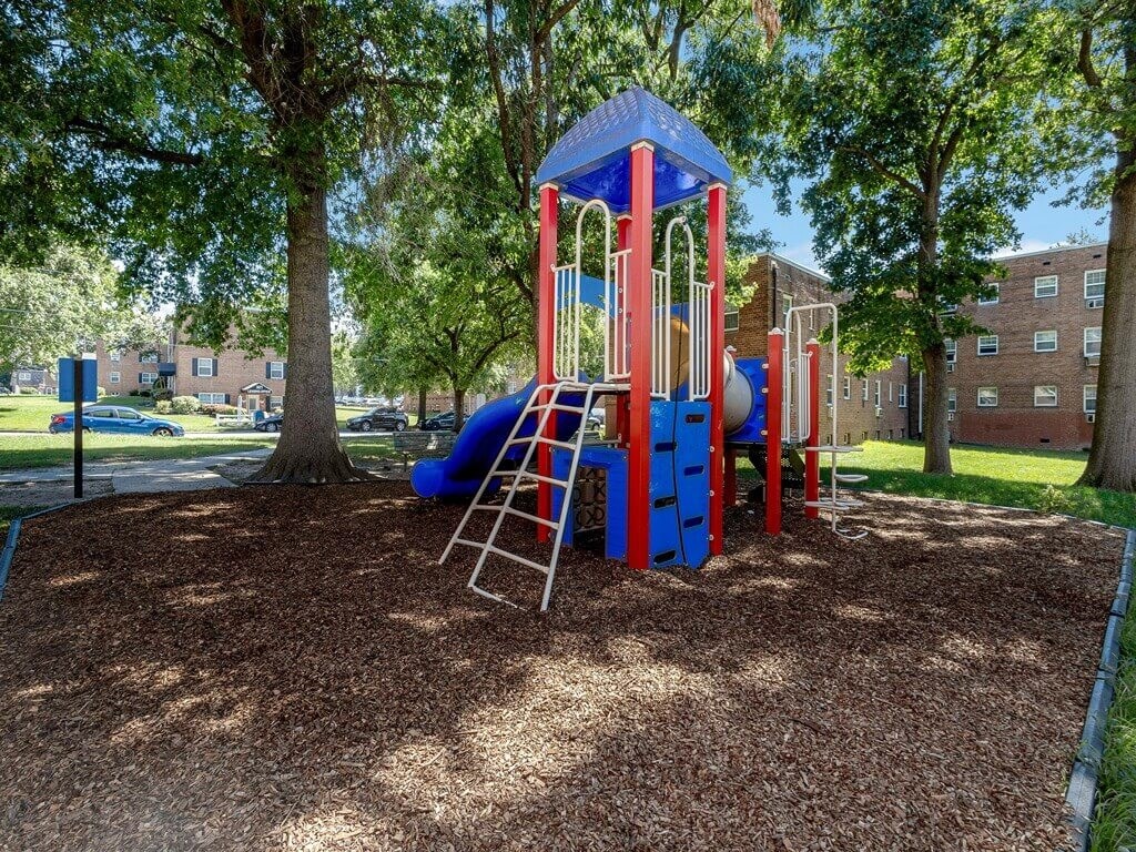 a playground with a blue and red swing set