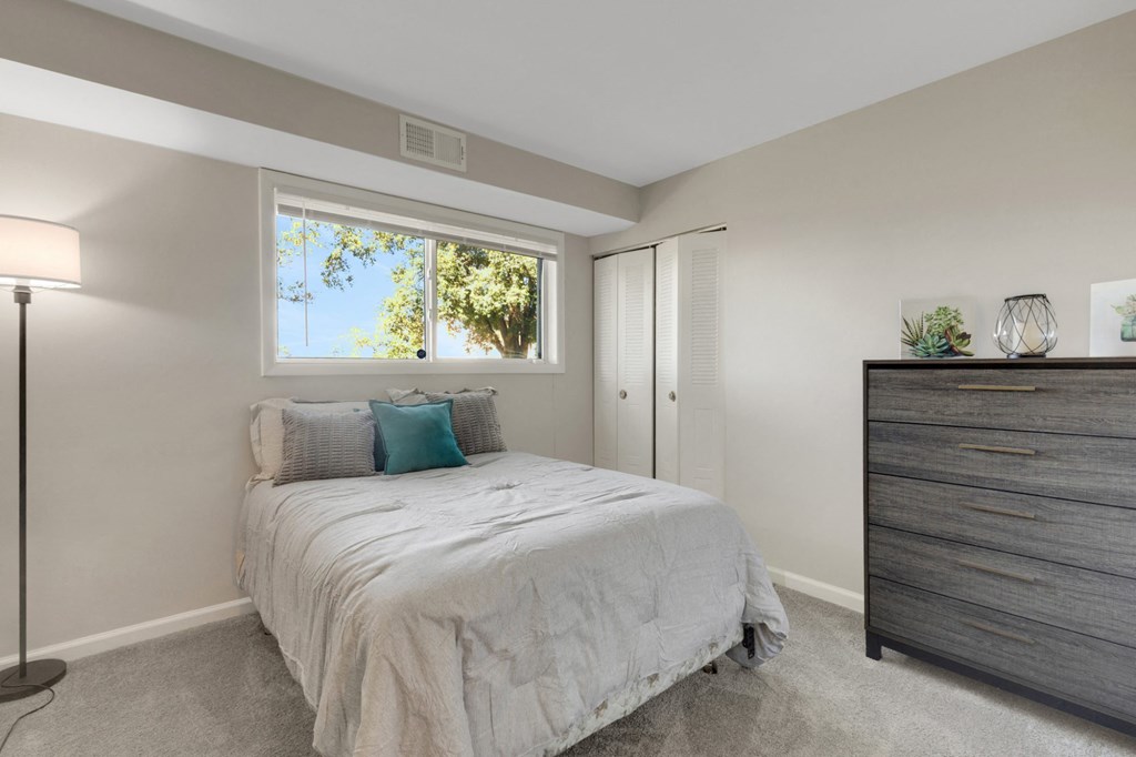 A bedroom with a bed, nightstand, and lamp.