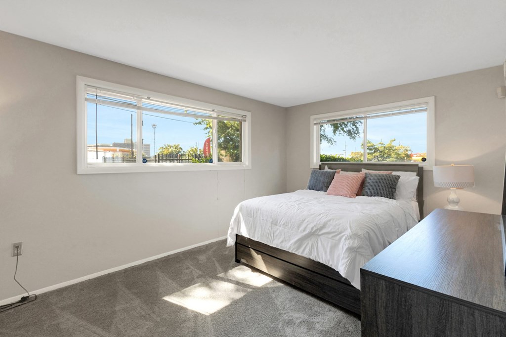 A bedroom with a large bed and a window overlooking a street.