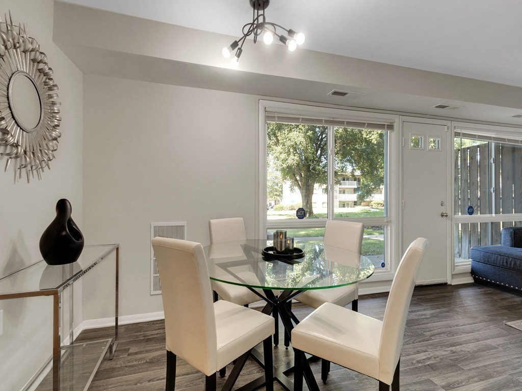 a dining room with a glass table and white chairs
