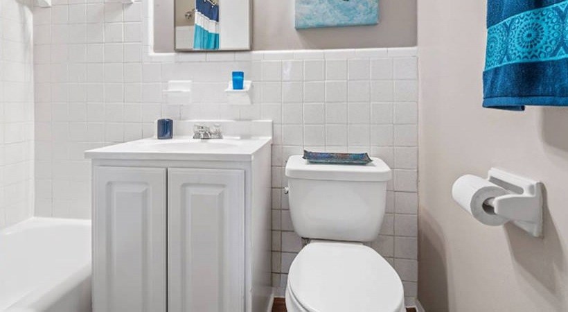 A white toilet sits next to a white sink in a bathroom.