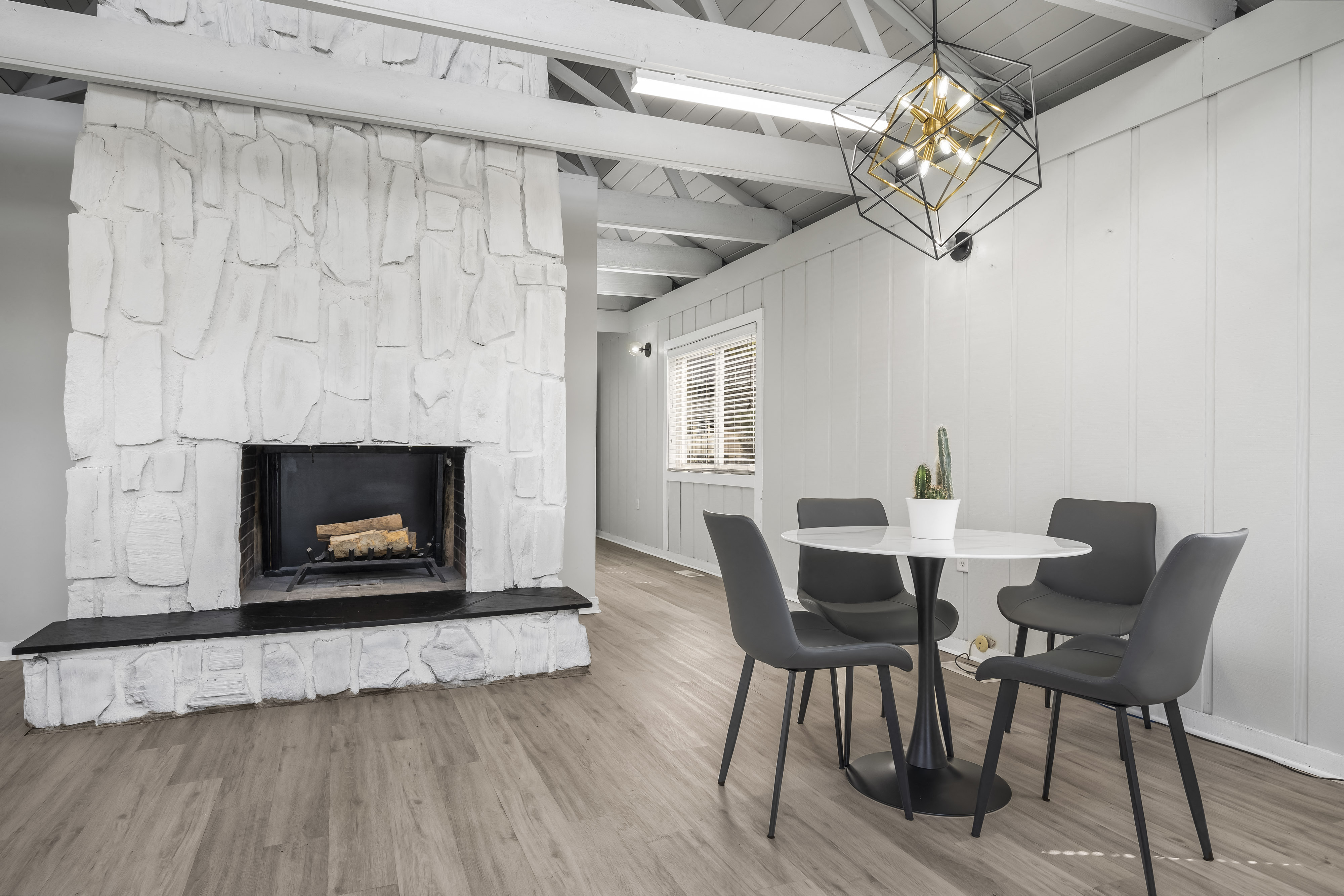 a living room with a fireplace and a table and chairs