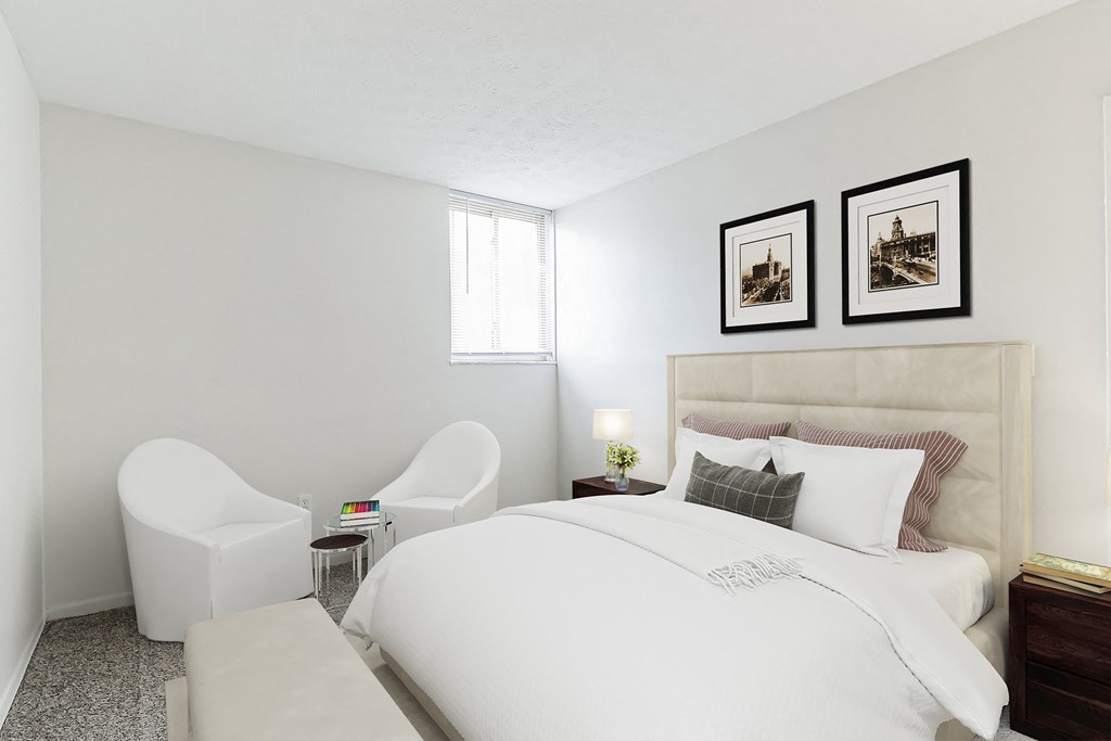a bedroom with a large white bed and two white chairs