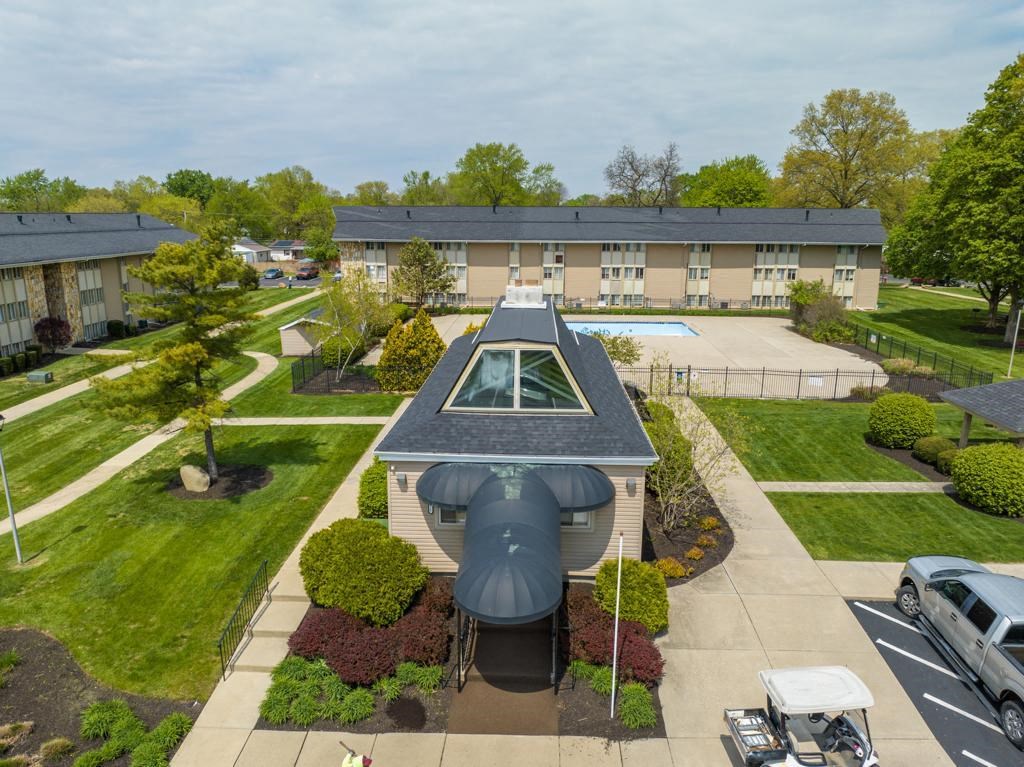 an aerial view of a building with a pool and a roof shaped like an airplane