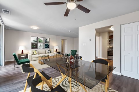 A modern dining room with a glass table and chairs.