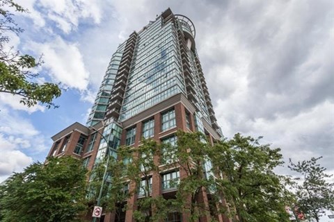 A tall building with a glass facade and a no parking sign in front of it.