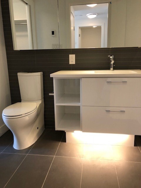 A white toilet and sink in a bathroom.