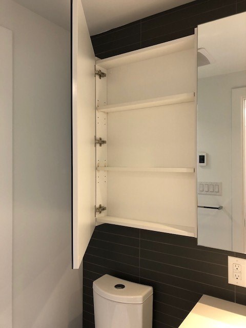 A white toilet is in a small bathroom.