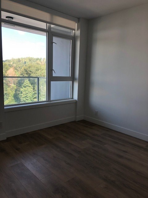 A room with a window overlooking a wooded area.