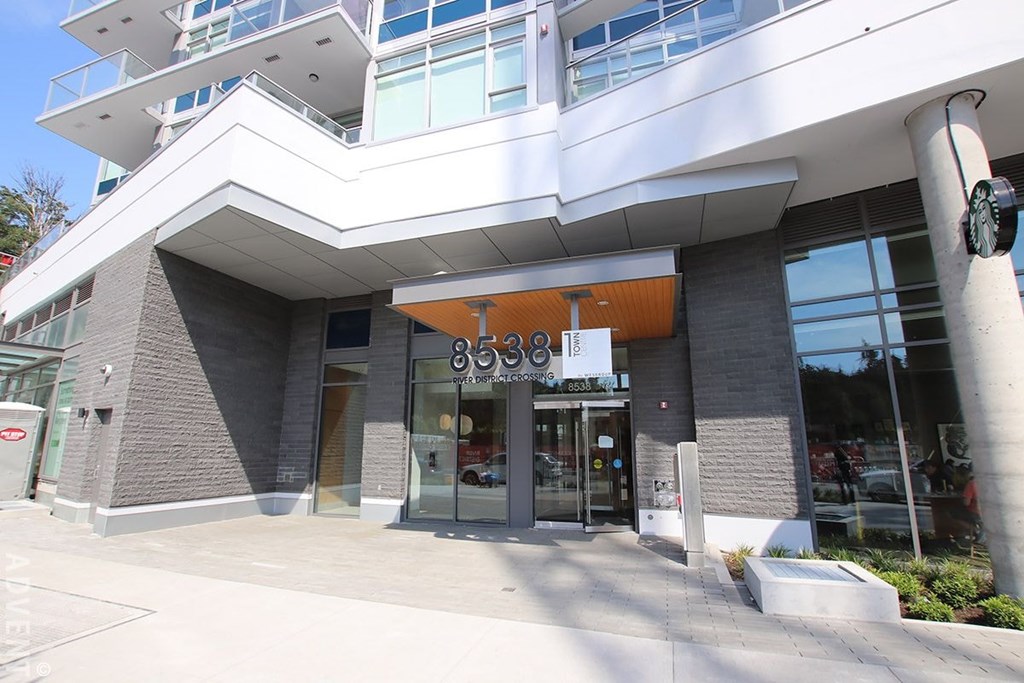 A modern building with a glass entrance and a white awning.