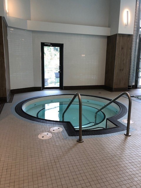 A small indoor pool with a metal railing.