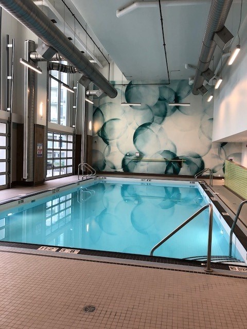 A large indoor swimming pool with a mural on the wall.