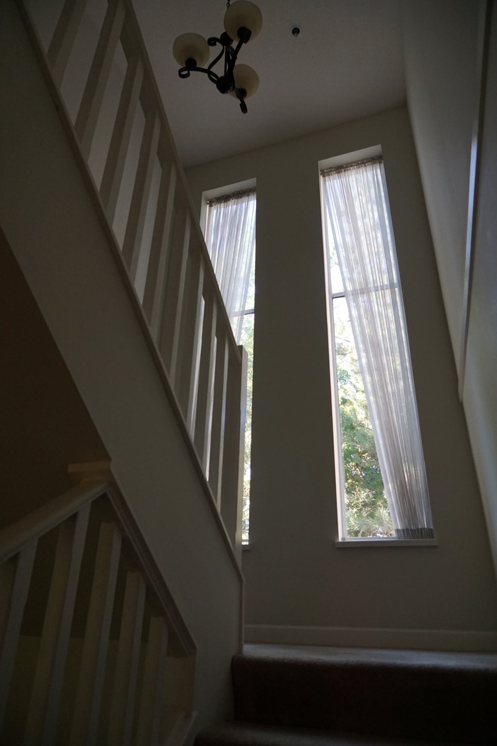 A staircase with a chandelier hanging from the ceiling.