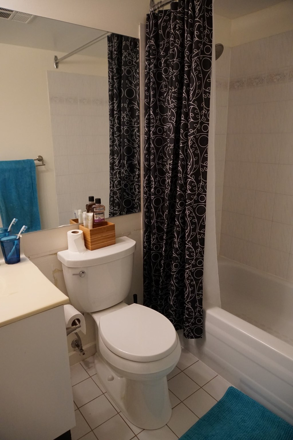 A white toilet sits next to a blue towel in a bathroom.
