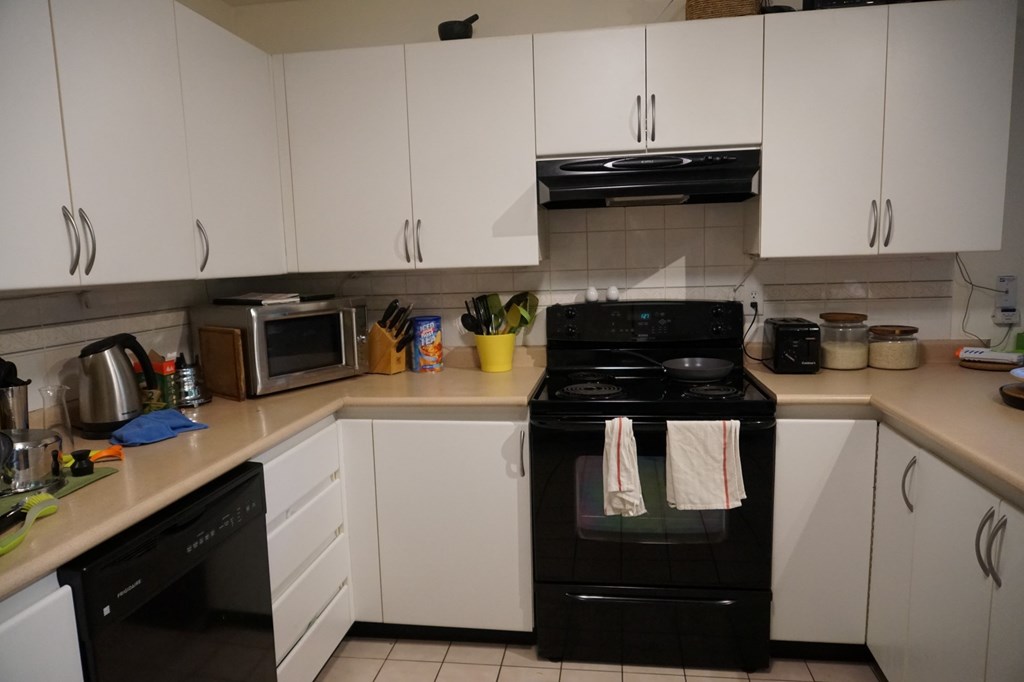 A black oven with a white towel hanging on it.