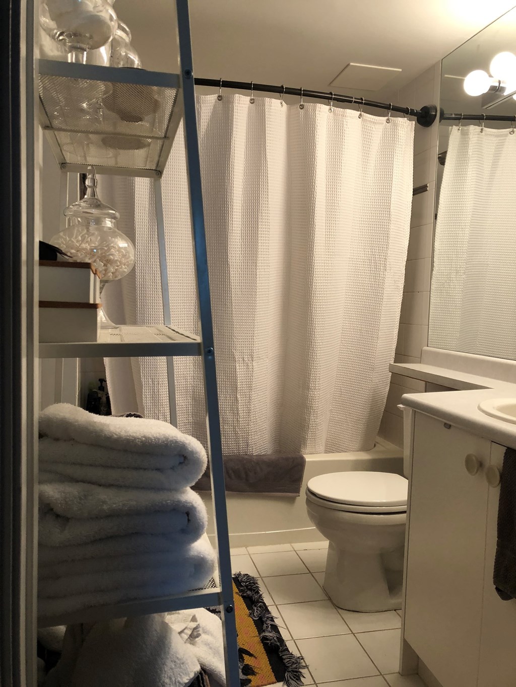 A white towel is hanging on a rack in a bathroom.