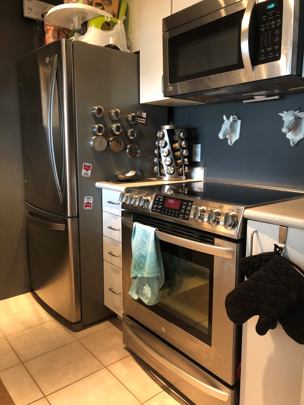 A kitchen with a stainless steel refrigerator, oven, and microwave.