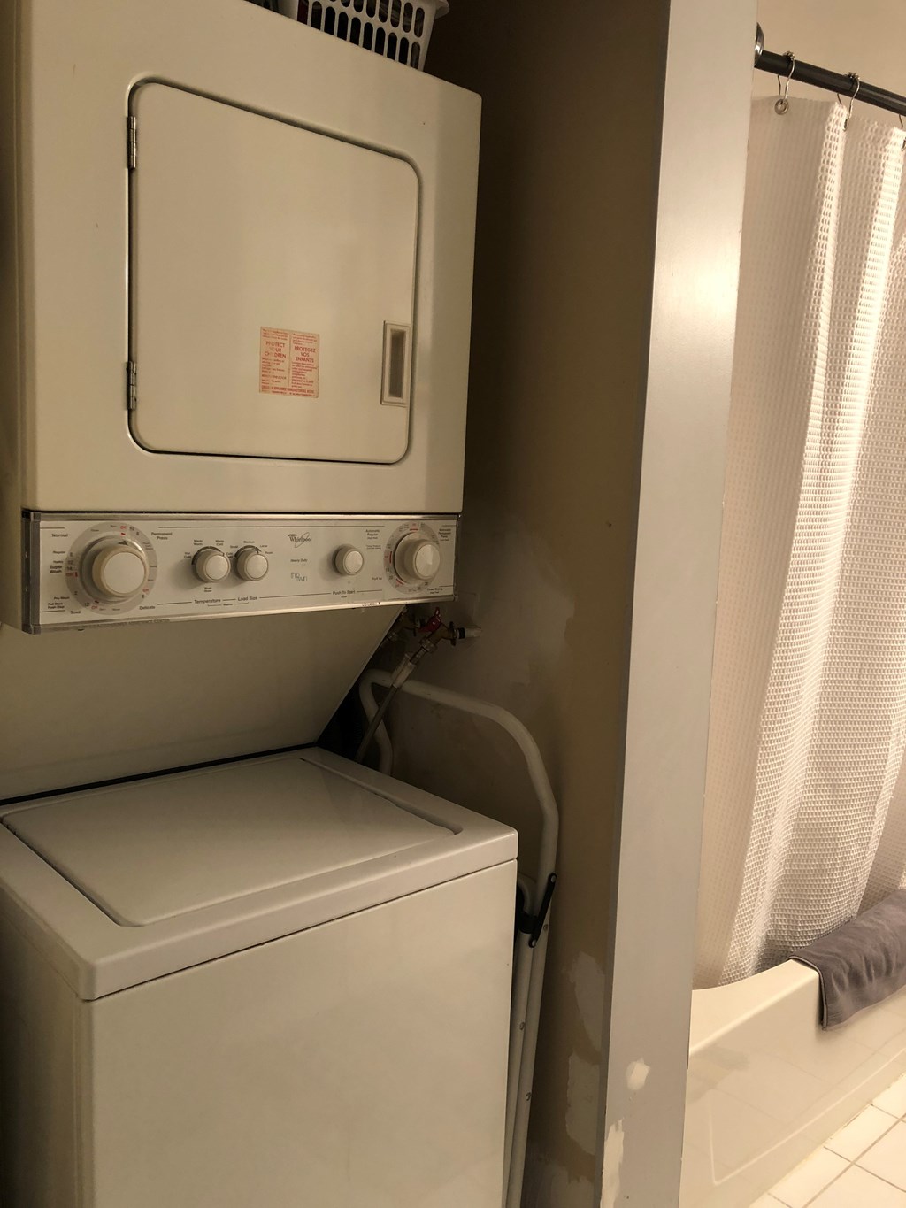 A white oven and dryer in a bathroom.