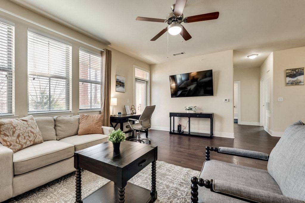 a living room with a couch and a table and a ceiling fan